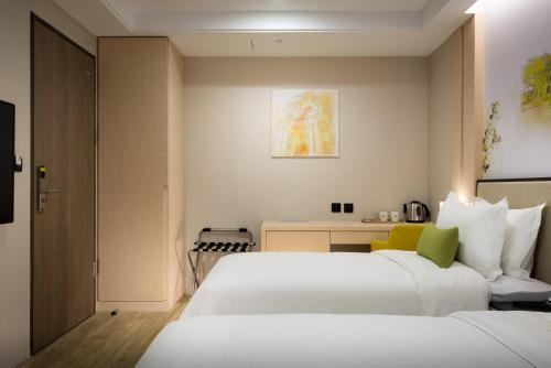 um quarto de hotel com duas camas e uma secretária em 星鑽國際商旅 編號315 em Tainan