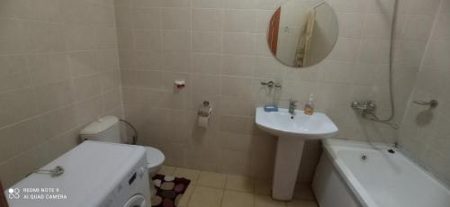 W łazience znajduje się umywalka, toaleta i lustro. w obiekcie Валиханова Абая w mieście Astana