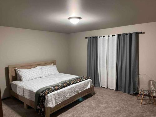 a bedroom with a bed and a window with curtains at 5 STAR Rating Home on Rock Island Golf Course 