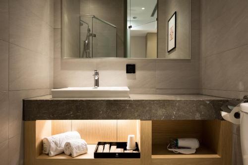 uma casa de banho com um lavatório e um balcão com toalhas em 星鑽國際商旅 編號315 em Tainan