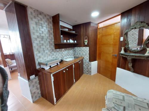 uma cozinha com armários de madeira e uma bancada em Villa Del Solar em Asia