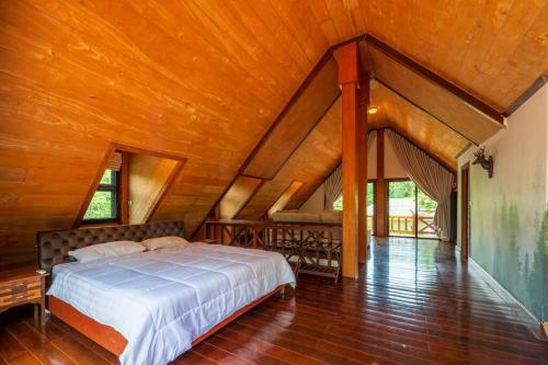 パクチョンにあるKhao Yai Log Houseの木製の天井が特徴のベッドルーム1室(ベッド1台付)