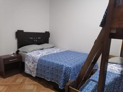 ein kleines Schlafzimmer mit einem Bett und einem Nachttisch in der Unterkunft MERINO HOUSE COLAN BEACH in Paita
