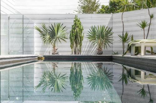 a swimming pool with plants on a fence at Pool House - Peaceful Luxury, Byron Bay in Byron Bay