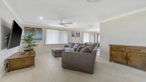 uma sala de estar com um sofá e uma televisão em Hooked On Hibbard em Port Macquarie