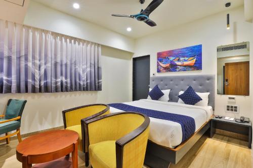 a bedroom with a bed and a table and chairs at FabHotel Prime Empyrean in Gandhinagar