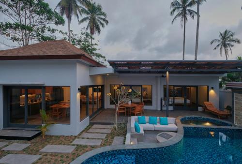 a villa with a swimming pool and a house at Tropik Resort Lombok in Selong Belanak