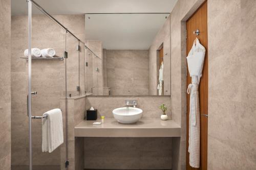 uma casa de banho com um lavatório e um chuveiro em Hyatt Place Bodh Gaya em Bodh Gaya