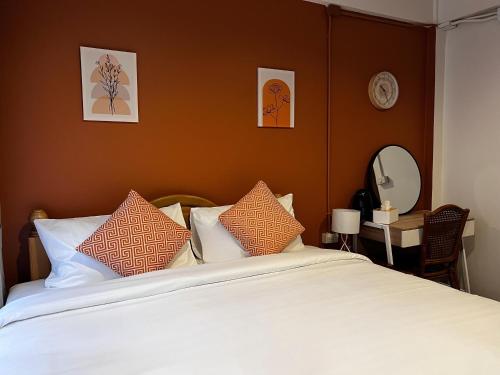 a bedroom with a bed with pillows and a mirror at SO One Silom Apartment in Bang Rak
