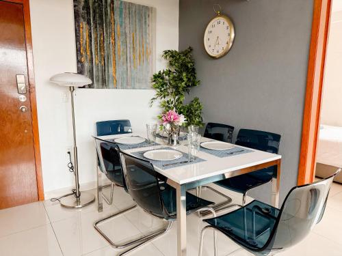 a dining room table with chairs and a clock on the wall at Beautiful Apartment, Airport, Downtown, Foro Sol in Mexico City