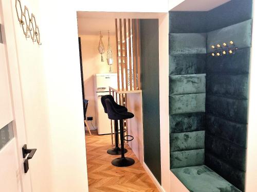 a hallway with a black chair in a room at Honey Aquapark View in Płock