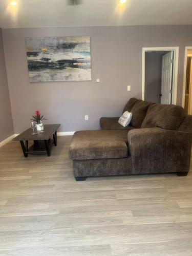 a living room with a brown couch and a table at A beautiful guest house/ Downey in Downey
