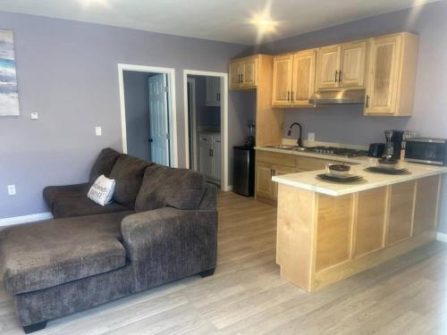 ein Wohnzimmer mit einem Sofa und einer Küche in der Unterkunft A beautiful guest house/ Downey in Downey