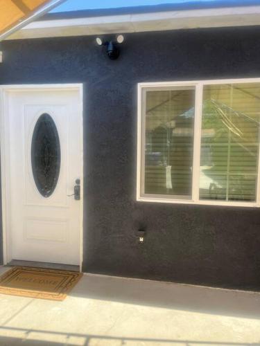 a house with a white door and two windows at A beautiful guest house/ Downey in Downey