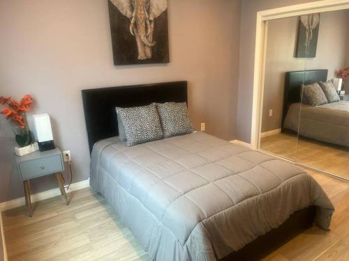 Schlafzimmer mit einem Bett und einem Spiegel in der Unterkunft A beautiful guest house/ Downey in Downey
