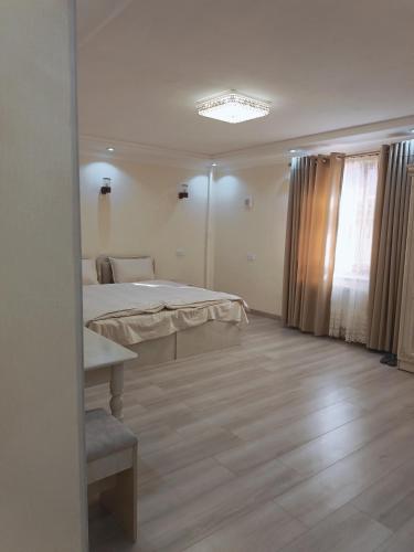 a white bedroom with a bed and a window at Dari Zanjir in Samarkand