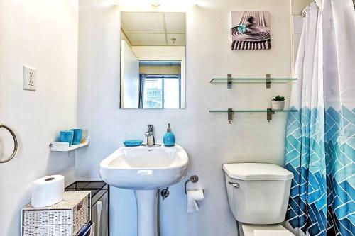 Baño blanco con lavabo y aseo en Industrial-Style Cityscape 1 Bedroom Loft, en Edmonton