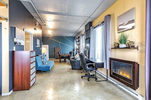 a living room with a fireplace and a desk and a couch at Industrial-Style Cityscape 1 Bedroom Loft in Edmonton