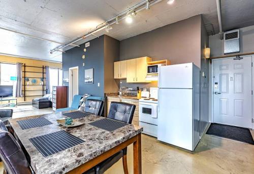 a kitchen with a table and a white refrigerator at Industrial-Style Cityscape 1 Bedroom Loft in Edmonton