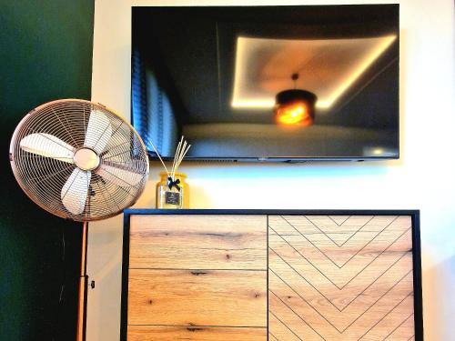 a room with a fan and a dresser at Honey Aquapark View in Płock