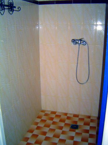 a bathroom with a shower with a checkered floor at Chez Meriem in Merzouga