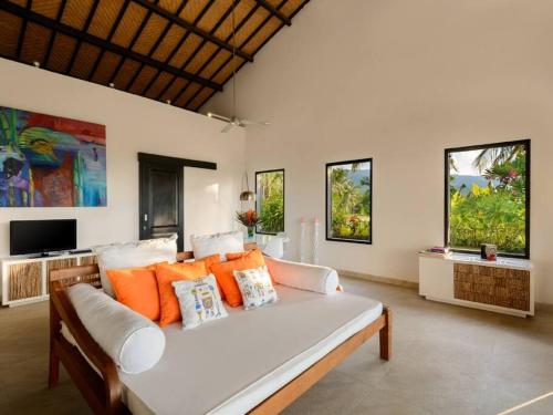 ein Wohnzimmer mit einem weißen Sofa und einem TV in der Unterkunft Seaview Villa near Lovina - Villa Bloom in Buleleng