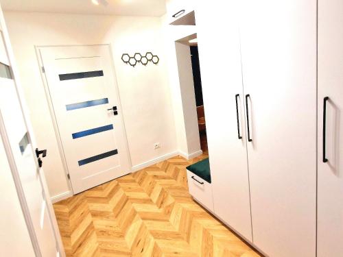 a hallway with white cabinets and a hard wood floor at Honey Aquapark View in Płock