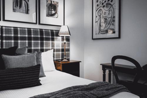 a bedroom with a bed and a desk with a lamp at Hotel Bellinzona Daylesford in Hepburn Springs