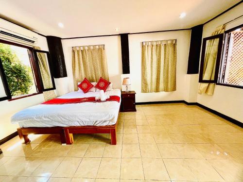 a bedroom with a bed in a room with windows at Vieng Savanh II Hotel in Luang Prabang