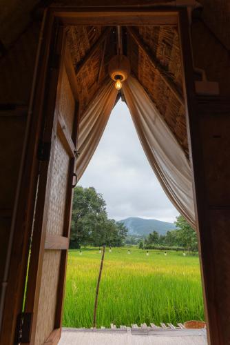 an open door with a view of a rice field at Paddy Fields Haven - Natures Nest in Pai