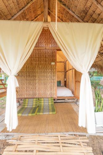 a bedroom with a bed and curtains in a room at Paddy Fields Haven - Natures Nest in Pai