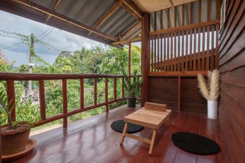 a wooden porch with a bench and a table at Paddy Fields Haven - Natures Nest in Pai