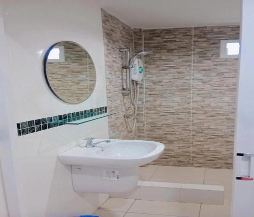 La salle de bains est pourvue d'un lavabo et d'une douche avec un miroir. dans l'établissement Popular Lanta Resort, à Ko Lanta