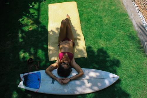 a woman in a bikini laying on a surfboard at SHANTI SURF CAMP in El Paredón Buena Vista
