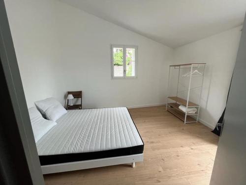 um quarto branco com uma cama e uma janela em Gîte rénové 6 pers, grand jardin, très calme em Saint-Michel-en-lʼHerm