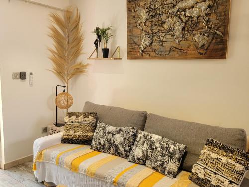 sala de estar con sofá y mapa en la pared en Studio Cosy" La Cigale", en Fréjus