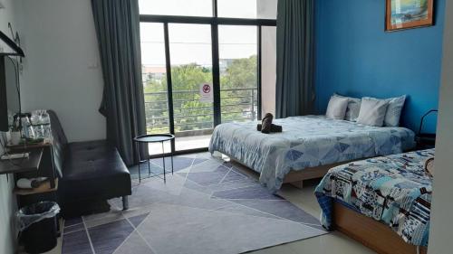 a bedroom with two beds and a window with a cat on the bed at HOMEY-Sleepy Don Mueang Airport Hostel in Bangkok