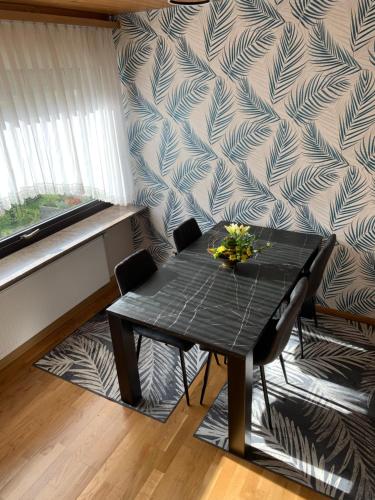 uma mesa preta com flores numa sala em Haus Nummer Vier em Neunkirchen