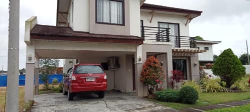 a red car parked in front of a house at Bloomfields Residences in Balintiouac