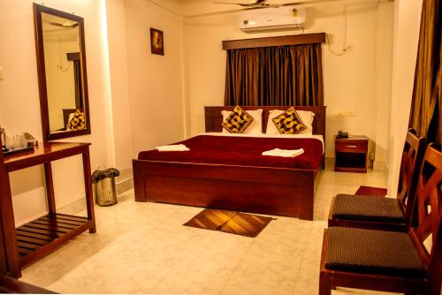 una camera con un letto e un grande specchio di HOTEL AQUA BREEZE a Port Blair