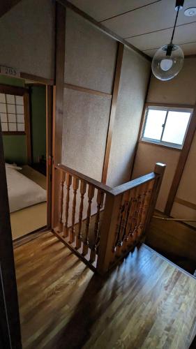 a staircase in a room with a bed and a window at KIX House Waraku III 和楽三号館 in Izumi-Sano