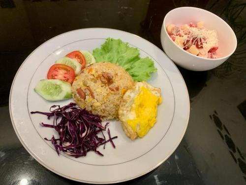 un piatto bianco con cibo su un tavolo di Good Feeling Hostel a Banyuwangi
