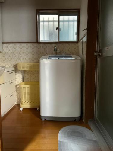 a small white sink in a kitchen with a window at KIX House Waraku III 和楽三号館 in Izumi-Sano