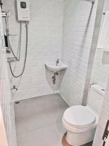 a white bathroom with a toilet and a sink at Jira19Hostel in Bangkok