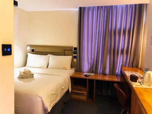 una habitación de hotel con una cama y un escritorio en Sempre Premier Inn - MACTAN AIRPORT HOTEL, en Mactan