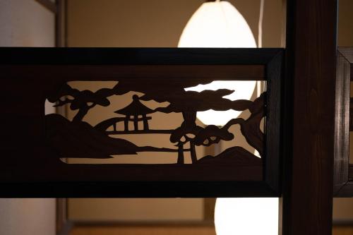 a picture frame with a painting of a tree silhouette at UFU Kanazawa in Kanazawa