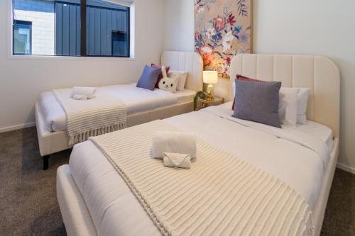 a room with two beds and a chair in it at Heart of Christchurch CBD Hideaway 2bed 1 bath in Christchurch