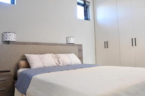 a bedroom with a bed and a white cabinet at Polles Εlies Cozy Αpartment in Aegina Town