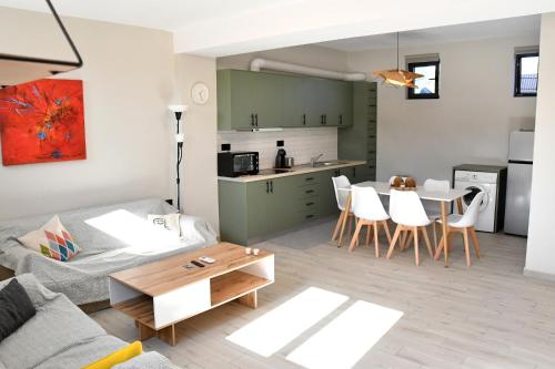 a living room with a couch and a table at Polles Εlies Cozy Αpartment in Egina