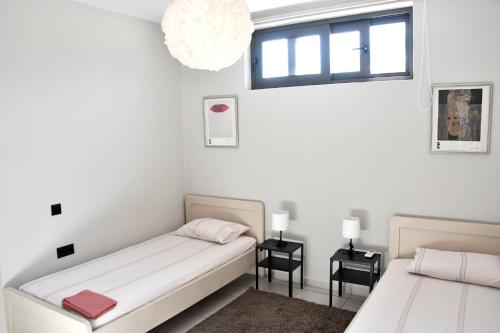 a bedroom with two beds and a window at Polles Εlies Cozy Αpartment in Egina